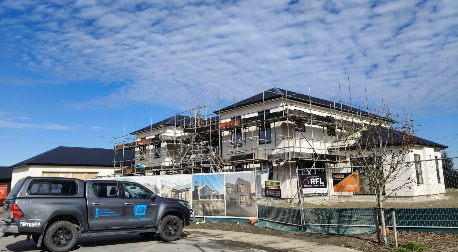 Two-storey new build under scaffolding during exterior plastering